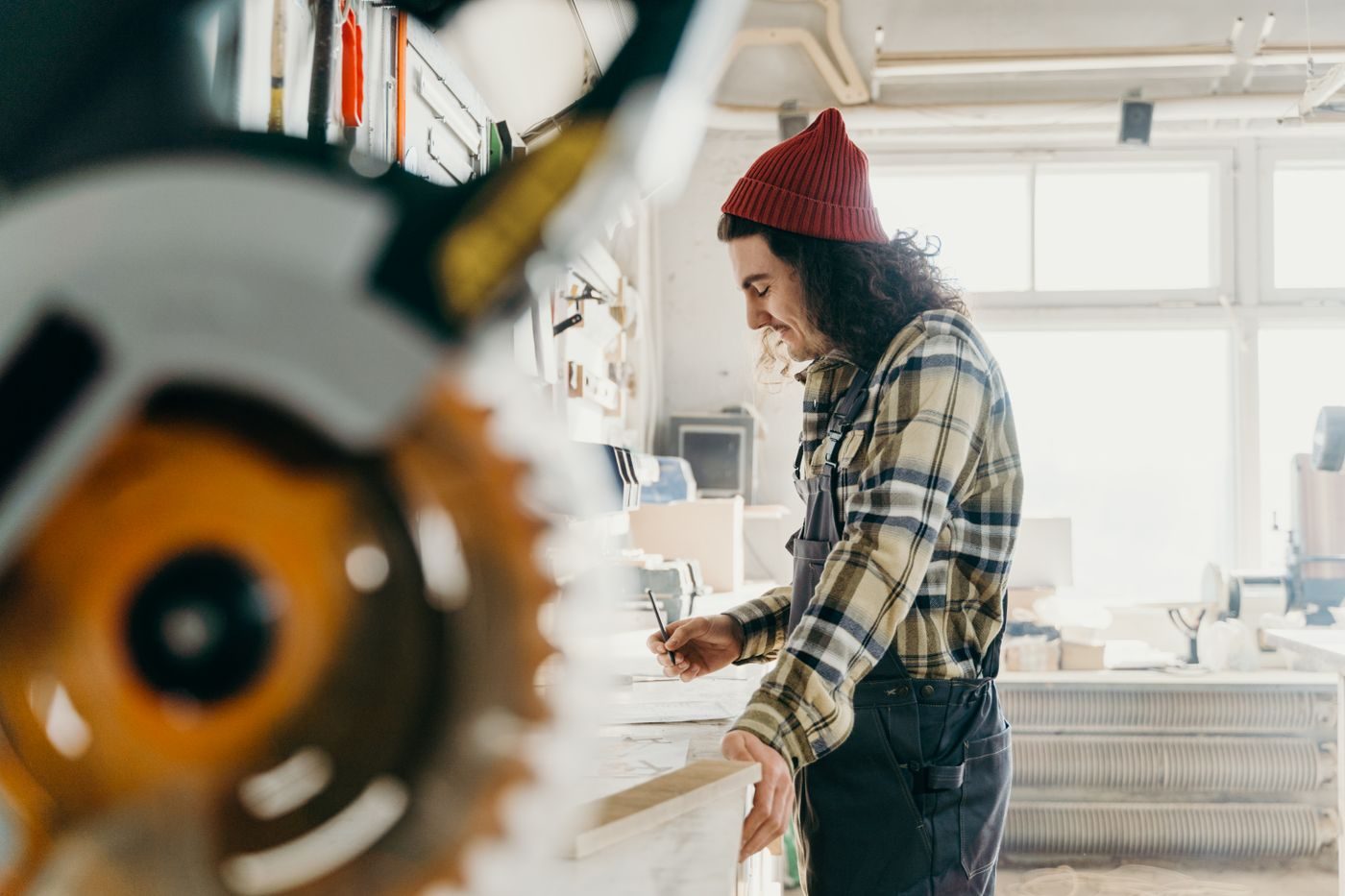 Menuisier préparant son travail dans un atelier lumineux